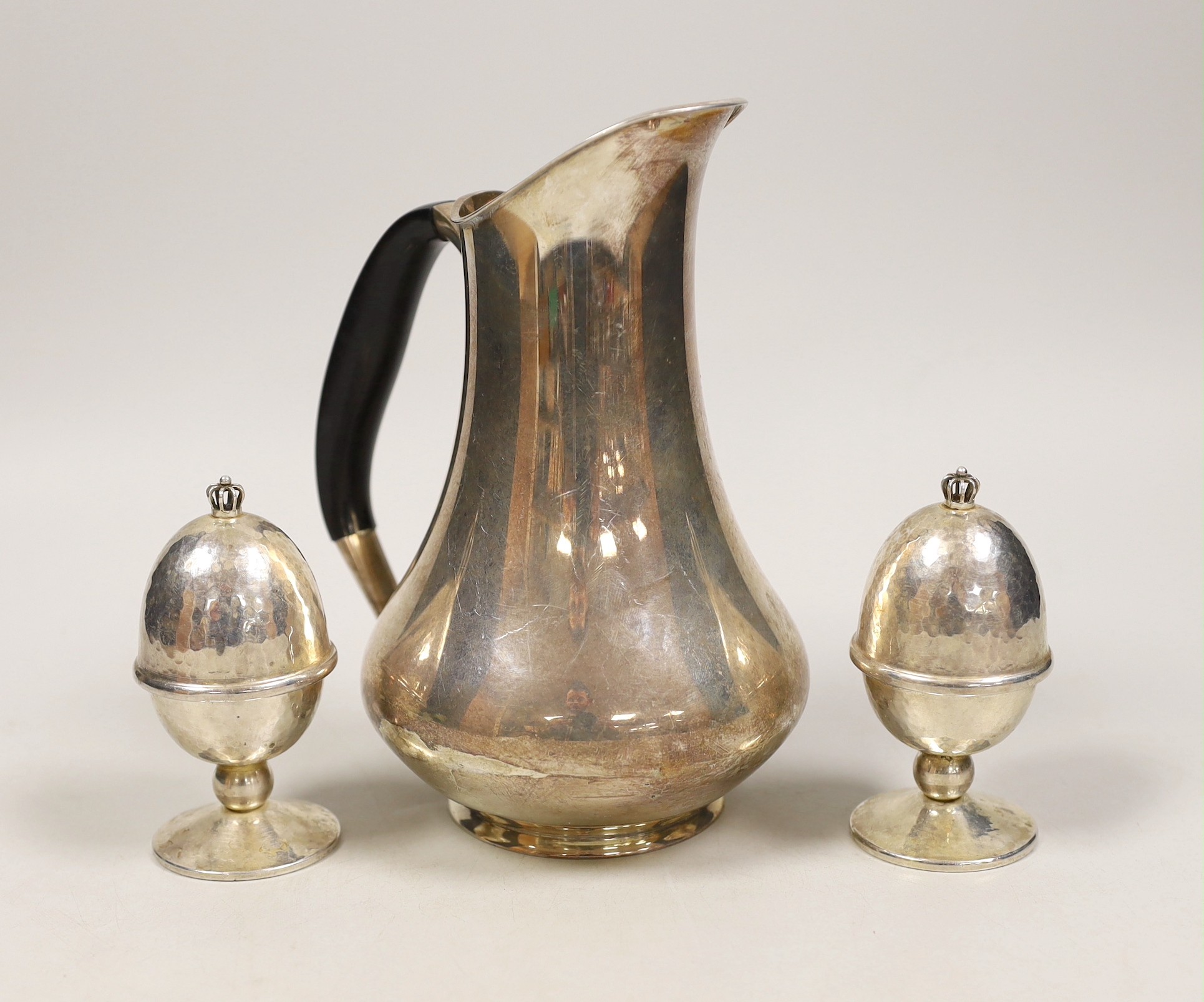 A Danish 830S white metal hot water jug, by Cohr, height 18.9cm and a pair of Danish sterling white metal egg cups and covers by Holmsted, gross weight 16.5oz.